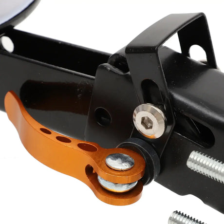 Close-up of a black bike component with an orange lever, showcasing precision mechanics and design for performance.