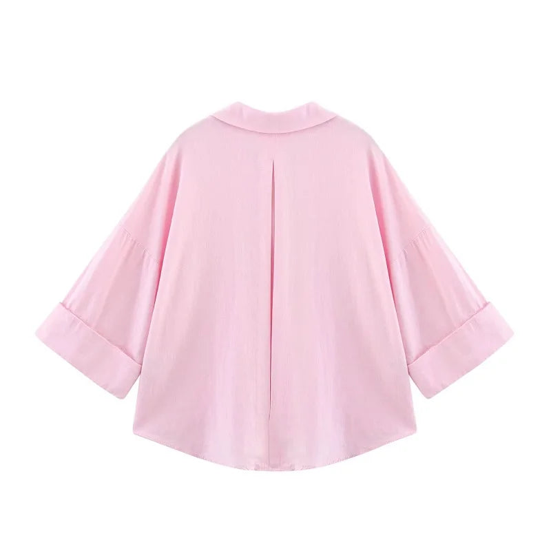 Back view of a loose-fit oversized pink striped shirt with turn-down collar and wide sleeves.