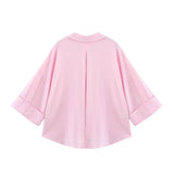 Back view of a loose-fit oversized pink striped shirt with turn-down collar and wide sleeves.