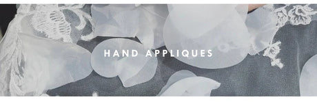 Close-up of delicate hand appliques showcasing white floral details on fabric.