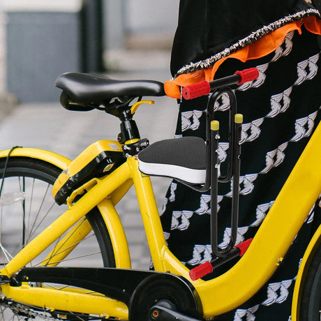 Kids electric bike seat saddle in black and white attached to a yellow bicycle, designed for comfort and safety.