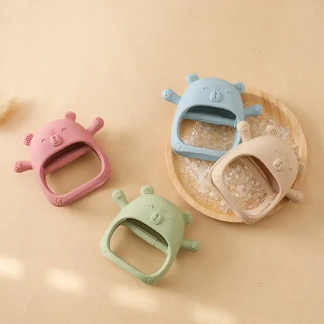 Colorful baby teether gloves in cute bear designs, made of soft silicone for toddlers aged 0-6 years.