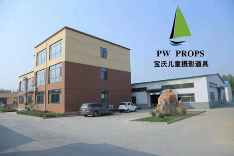 Exterior view of the PW Props building showcasing a modern design with vehicles parked outside and greenery.