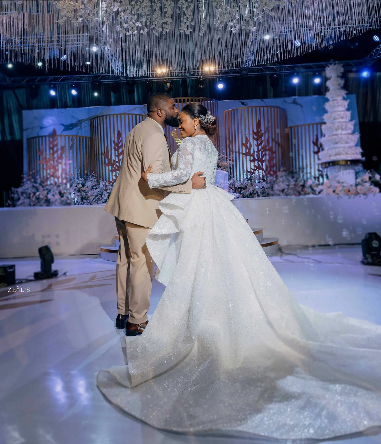 Bride and groom dancing at a wedding celebration in a stunning mermaid dress with a detachable train.