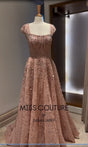 Elegant pink evening gown by Miss Couture, featuring intricate beadwork and a floor-length design.