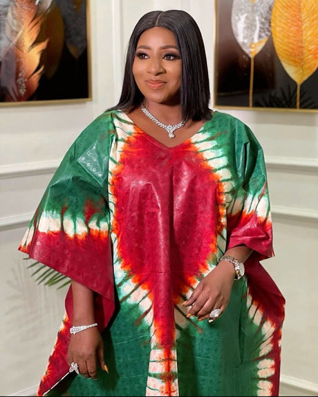 Stylish woman wearing a colorful African long maxi dress with a vibrant tie-dye pattern.