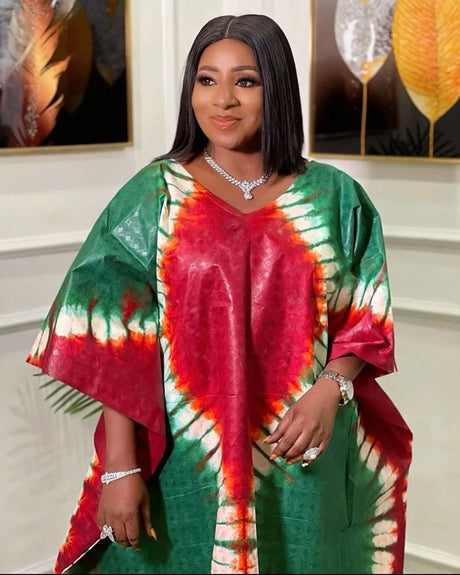 Elegant African woman wearing a colorful, printed long maxi dress with traditional patterns.