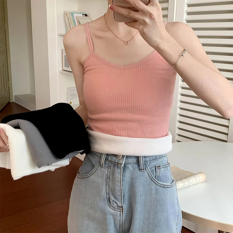 Woman wearing a pink ribbed crop tank top, showcasing its casual style and sleeveless design.