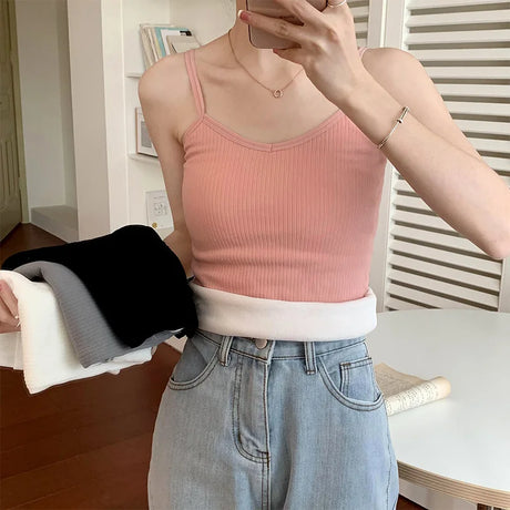 Woman wearing a pink ribbed crop tank top, showcasing its casual style and sleeveless design.