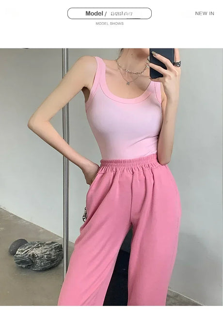 Model wearing a pink ribbed tank top and pink pants, showcasing a trendy streetwear look.