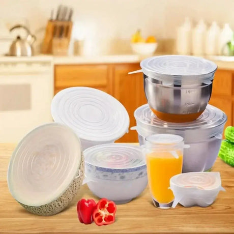 Various silicone food covers on bowls and containers in a kitchen setting for reusable and airtight storage.