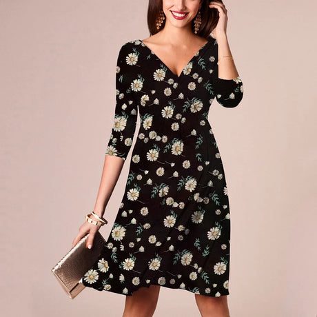 Woman wearing a floral V-neck knee-length maternity dress, summer nursing dress in black with daisies.