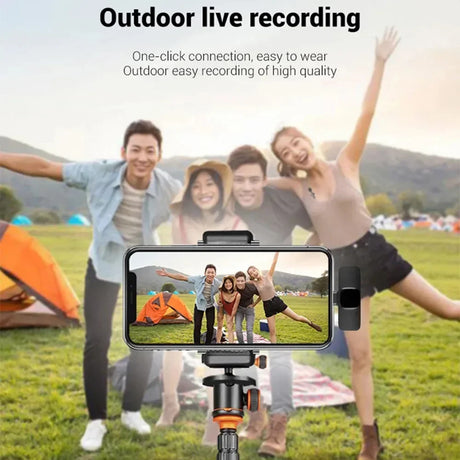 Group of friends enjoying outdoor live recording with smartphone on tripod in nature.