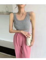 Model wearing a gray sleeveless ribbed tank top paired with pink trousers, showcasing retro streetwear style.