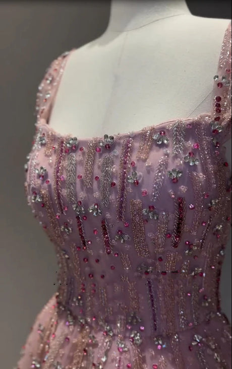Detail of a glitter crystal mermaid wedding gown with beaded and embroidered embellishments in soft pink.