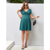 Pure Color V-Neck Maternity Dress in teal, knee-length, perfect for summer, worn by model with chic accessories.