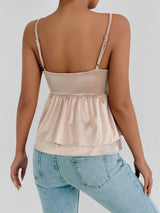 Back view of a woman wearing a ruffle strap V-neck backless crop top in beige, paired with light blue jeans.