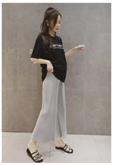 Woman wearing breathable adjustable maternity pants with wide leg design, ideal for summer, paired with a casual black t-shirt.