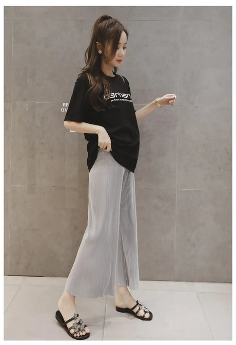 Woman wearing breathable adjustable maternity pants with wide leg design, ideal for summer, paired with a casual black t-shirt.