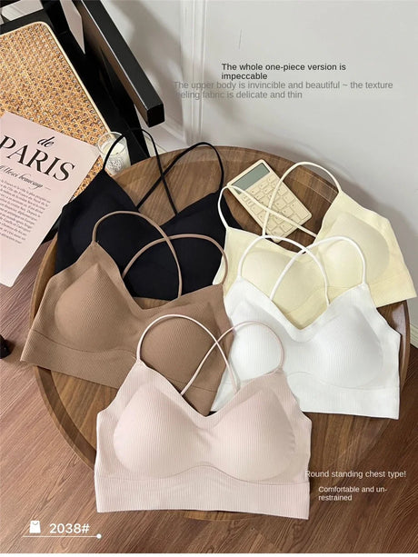 Assorted colors of CrossForm™ padded backless tank tops displayed on a wooden table, featuring soft fabric and trendy design.