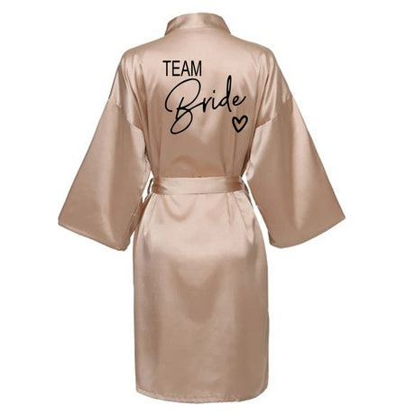Team Bride satin robe in soft pink with elegant lettering on the back, perfect for bridal parties.