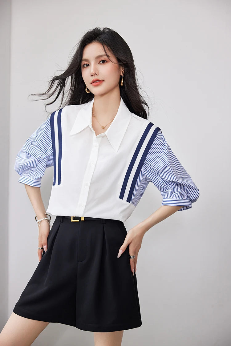 Woman wearing StripeMuse™ Colorblock Chiffon Shirt with blue striped sleeves and black shorts, showcasing a casual office look.
