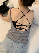 Back view of a young woman wearing a CrossForm™ padded tank top with a stylish crisscross design.