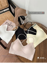 CrossForm™ padded backless tank tops in various colors on a wooden table, showcasing summer styles for women.