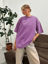 Stylish woman in a loose-fitting purple casual t-shirt, pairing it with light-colored jeans.
