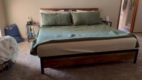 Vintage metal bed frame with green bedding in a cozy bedroom setting.