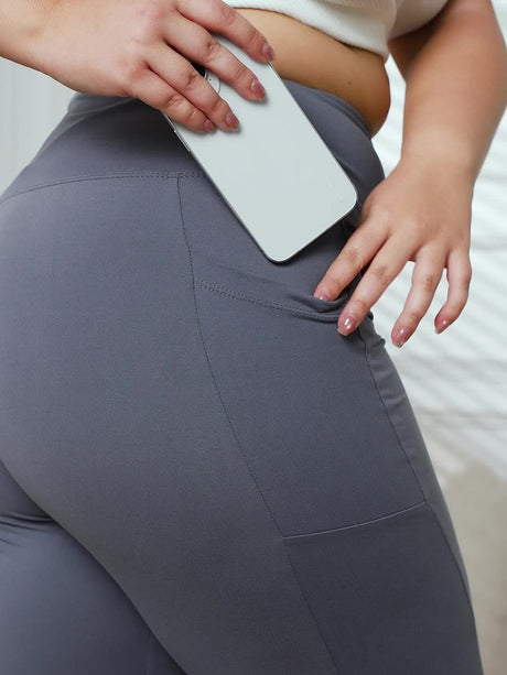 Model wearing grey stretch polyester leggings with a side pocket, showcasing comfort and style.
