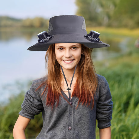 A young girl wearing a men's adjustable fan hat by a lake, showcasing its unique fan features and stylish design.