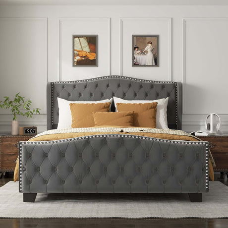 Contemporary bed frame with tufted gray upholstery, decorative nailhead trim, and plush bedding in a stylish bedroom setting.