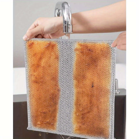 Hand holding a non-stick oil dishwashing cloth under running water, showcasing its effective cleaning design.