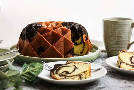 Delicious marbled cake served in a fluted silicone cake pan, showcasing a rich swirl pattern on a rustic table setting.