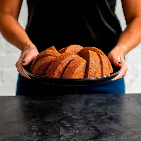 Deliciously baked fluted cakes presented on a black plate, made using a nonstick silicone cake pan set.